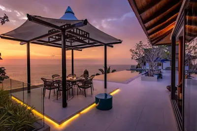 a patio with a table and chairs and the ocean at Villa La Thale in Phuket Town