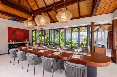 a large dining room with a long table and chairs at Villa La Thale in Phuket Town