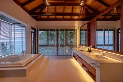 a bathroom with a large tub and a large mirror at Villa La Thale in Phuket Town