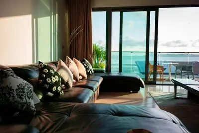a living room with a couch and a view of the ocean at EVA Beach sea view Four room villa in Ban Saiyuan (1)