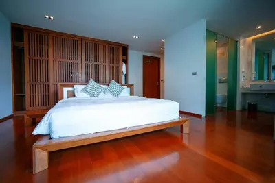 a bedroom with a white bed and a wooden floor at EVA Beach sea view Four room villa in Ban Saiyuan (1)