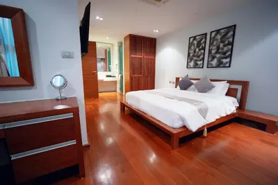 a bedroom with a large bed and a wooden floor at EVA Beach sea view Four room villa in Ban Saiyuan (1)