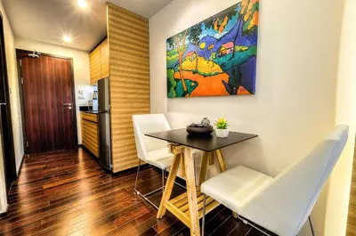 a small dining room with a table and white chairs at The Title Boutique Phuket in Rawai Beach