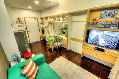 a living room with a couch and a flat screen tv at The Title Boutique Phuket in Rawai Beach