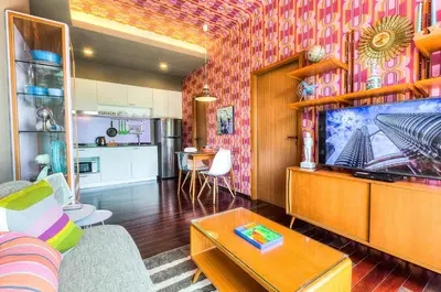 a living room with a couch and a tv at The Title Boutique Phuket in Rawai Beach