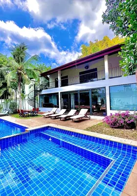 a swimming pool in front of a house at Coconut Palms Villa, Large & Elegant Private Pool Villa in Rawai, Phuket in Ban Saiyuan (1)