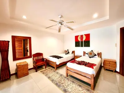 a bedroom with two beds and a ceiling fan at Coconut Palms Villa, Large & Elegant Private Pool Villa in Rawai, Phuket in Ban Saiyuan (1)