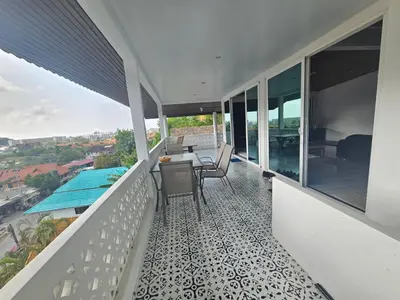 a balcony of a house with a table and chairs at Castle Villa Phuket in Kamala Beach