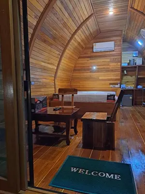 a room with a bed and a table and a welcome mat at Seaview Eagles Nest Cabins in Rawai Beach