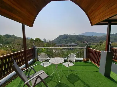 a patio with a table and chairs on a balcony at Seaview Eagles Nest Cabins in Rawai Beach
