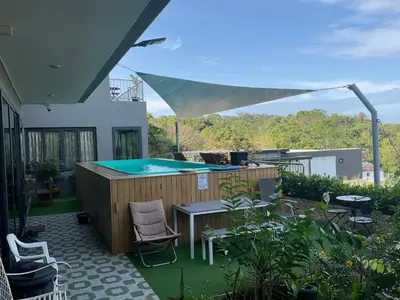 a patio with a pool and a table and chairs at Seaview Eagles Nest Cabins in Rawai Beach