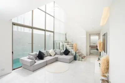 a living room with a couch and a large window at Aesthetic 3 Storey Villa Residence A23, Private Pool, close to Ma Doo Bua Café and Laguna in Bang Tao Beach