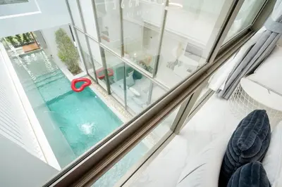 a pool seen through a window with a red handle at Aesthetic 3 Storey Villa Residence A23, Private Pool, close to Ma Doo Bua Café and Laguna in Bang Tao Beach