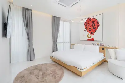 a white bedroom with a bed and a couch at Aesthetic 3 Storey Villa Residence A23, Private Pool, close to Ma Doo Bua Café and Laguna in Bang Tao Beach