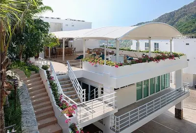a building with a balcony with flowers on it at Boho chic sea view apartment in Kata in Kata Beach