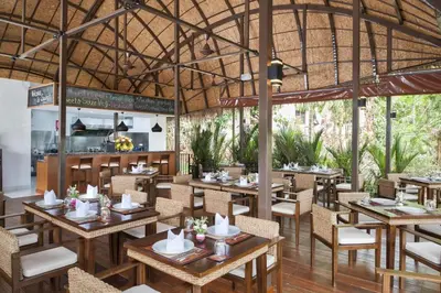 a restaurant with wooden tables and chairs and a kitchen at Boho chic sea view apartment in Kata in Kata Beach