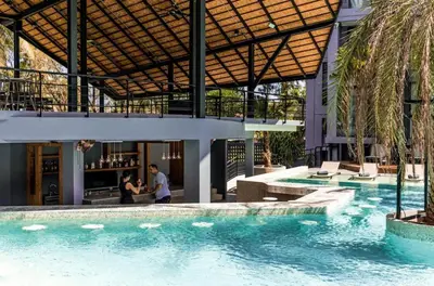 a swimming pool in a building with two people in the background at Deluxe apartment Citygate Condo by Lofty in Kamala Beach