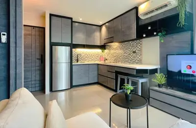 a living room with a couch and a kitchen at Deluxe apartment Citygate Condo by Lofty in Kamala Beach