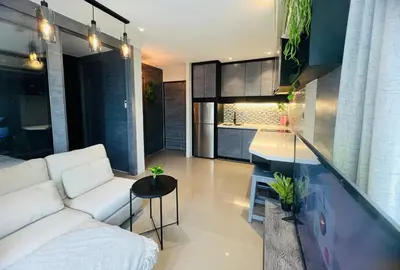 a living room with a white couch and a kitchen at Deluxe apartment Citygate Condo by Lofty in Kamala Beach