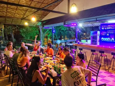 a group of people sitting at a table in a restaurant at Charming Pool Twin Holiday Home in Patong Beach