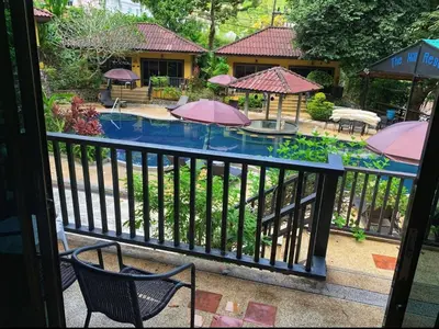 a view of a pool with chairs and umbrellas at Charming Pool Twin Holiday Home in Patong Beach
