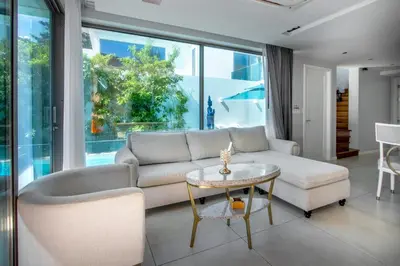 a living room with a couch and a table at \u3010Beach Front\u3011\u6d77\u666f\u6c99\u6ee9\u522b\u5885\uff0c\u79c1\u4eba\u6cf3\u6c60\uff0c\u514d\u8d39\u65e9\u9910\uff0c\u5973\u4f63\u6bcf\u65e5\u6e05\u6d01\uff0c\u751f\u6d3b\u65b9\u4fbf\u4ea4\u901a\u4fbf\u5229 in Phuket Town