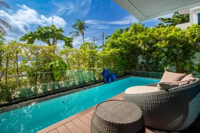 a patio with a swimming pool and two chairs at \u3010Beach Front\u3011\u6d77\u666f\u6c99\u6ee9\u522b\u5885\uff0c\u79c1\u4eba\u6cf3\u6c60\uff0c\u514d\u8d39\u65e9\u9910\uff0c\u5973\u4f63\u6bcf\u65e5\u6e05\u6d01\uff0c\u751f\u6d3b\u65b9\u4fbf\u4ea4\u901a\u4fbf\u5229 in Phuket Town