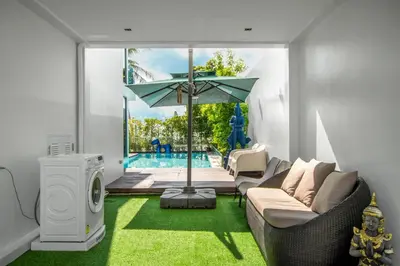 a living room with a couch and an umbrella at \u3010Beach Front\u3011\u6d77\u666f\u6c99\u6ee9\u522b\u5885\uff0c\u79c1\u4eba\u6cf3\u6c60\uff0c\u514d\u8d39\u65e9\u9910\uff0c\u5973\u4f63\u6bcf\u65e5\u6e05\u6d01\uff0c\u751f\u6d3b\u65b9\u4fbf\u4ea4\u901a\u4fbf\u5229 B in Phuket Town