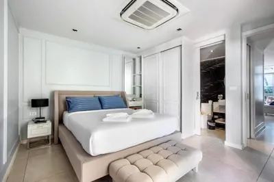 a bedroom with a large white bed with blue pillows at \u3010Beach Front\u3011\u6d77\u666f\u6c99\u6ee9\u522b\u5885\uff0c\u79c1\u4eba\u6cf3\u6c60\uff0c\u514d\u8d39\u65e9\u9910\uff0c\u5973\u4f63\u6bcf\u65e5\u6e05\u6d01\uff0c\u751f\u6d3b\u65b9\u4fbf\u4ea4\u901a\u4fbf\u5229 B in Phuket Town