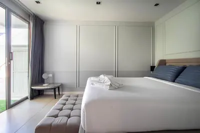 a bedroom with a large white bed and a window at \u3010Beach Front\u3011\u6d77\u666f\u6c99\u6ee9\u522b\u5885\uff0c\u79c1\u4eba\u6cf3\u6c60\uff0c\u514d\u8d39\u65e9\u9910\uff0c\u5973\u4f63\u6bcf\u65e5\u6e05\u6d01\uff0c\u751f\u6d3b\u65b9\u4fbf\u4ea4\u901a\u4fbf\u5229 B in Phuket Town