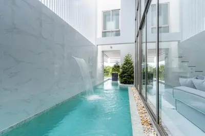 a swimming pool in a building with a water fountain at New Modern Aesthetic 3-Storey Villa A15 in Gated Residence just 10 min drive Laguna Phuket in Bang Tao Beach