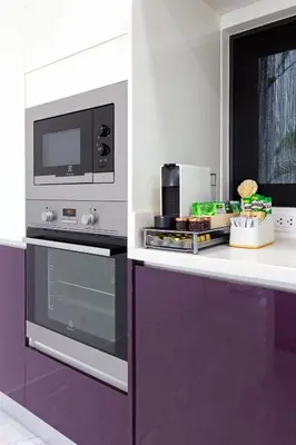 a kitchen with a stove and a microwave at Zen-Inspired Villa Retreat, Resort-Style Pool, Stunning Rooftop & Kid-Friendly Playground in Rawai Beach