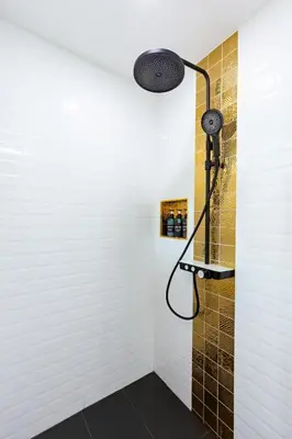 a shower with a shower head in a bathroom at Zen-Inspired Villa Retreat, Resort-Style Pool, Stunning Rooftop & Kid-Friendly Playground in Rawai Beach