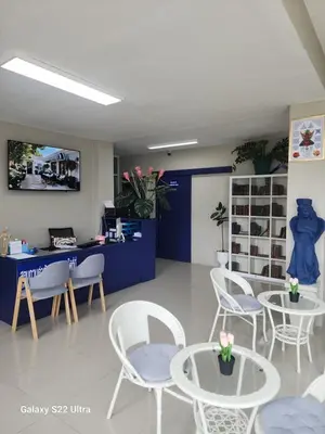 a waiting room with white chairs and tables and a blue wall at Angels 