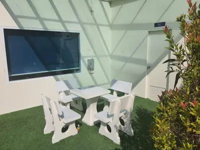 a white table and chairs in a room with a tv at Angels 