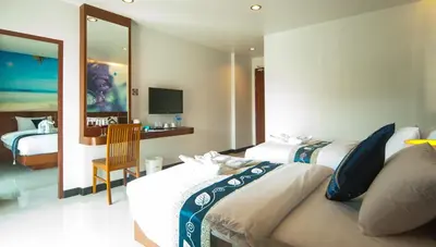 a hotel room with two beds and a television at The Crystal Beach Hotel in Patong Beach