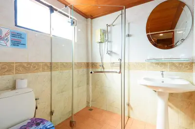 a bathroom with a shower and a toilet and a sink at Bungalow Phuket in Kamala Beach