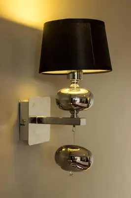 a lamp attached to a wall with a light on it at Two Chefs Inn in Kata Beach