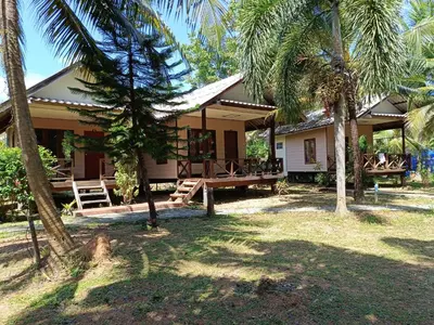 a house with palm trees in front of it at Mangrove House Kohyao noi in Ban Bang Chak