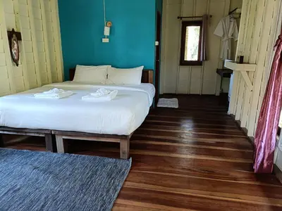 a bedroom with two beds and a wooden floor at Mangrove House Kohyao noi in Ban Bang Chak