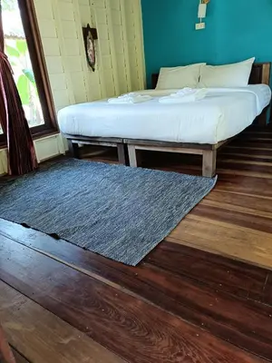 a bedroom with two beds and a rug on the floor at Mangrove House Kohyao noi in Ban Bang Chak