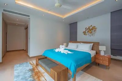 a bedroom with a large bed with a blue blanket at 3BR Villa with Pool at Anchan Hills in Bangtao in Bang Tao Beach