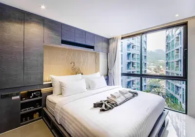 a bedroom with a large bed with a large window at Citygate Condo Kamala Phuket in Kamala Beach