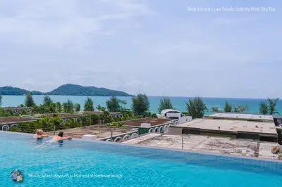 two people in a swimming pool with a view of the water at Beachfront Deluxe Infinity Pool in Patong Beach