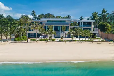 a large house on the beach with the ocean at Villa Boonta in Phuket Town