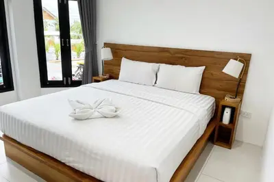a bedroom with a white bed with a bow on it at Peacefully Rawai 3 Bedrooms Pool Villa in Rawai Beach