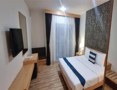 a hotel room with a bed and a flat screen tv at iCheck inn Central Patong in Patong Beach
