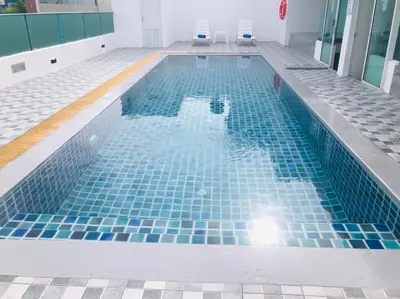 a swimming pool with blue tiles on the floor at iCheck inn Central Patong in Patong Beach