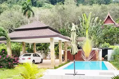 a house with a car parked next to a swimming pool at 2 Bedrooms Pool Villa in Kamala in Kamala Beach