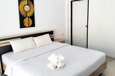 a white bed with a stuffed elephant sitting on it at 3 Bedrooms Pool Villa in Kamala in Kamala Beach